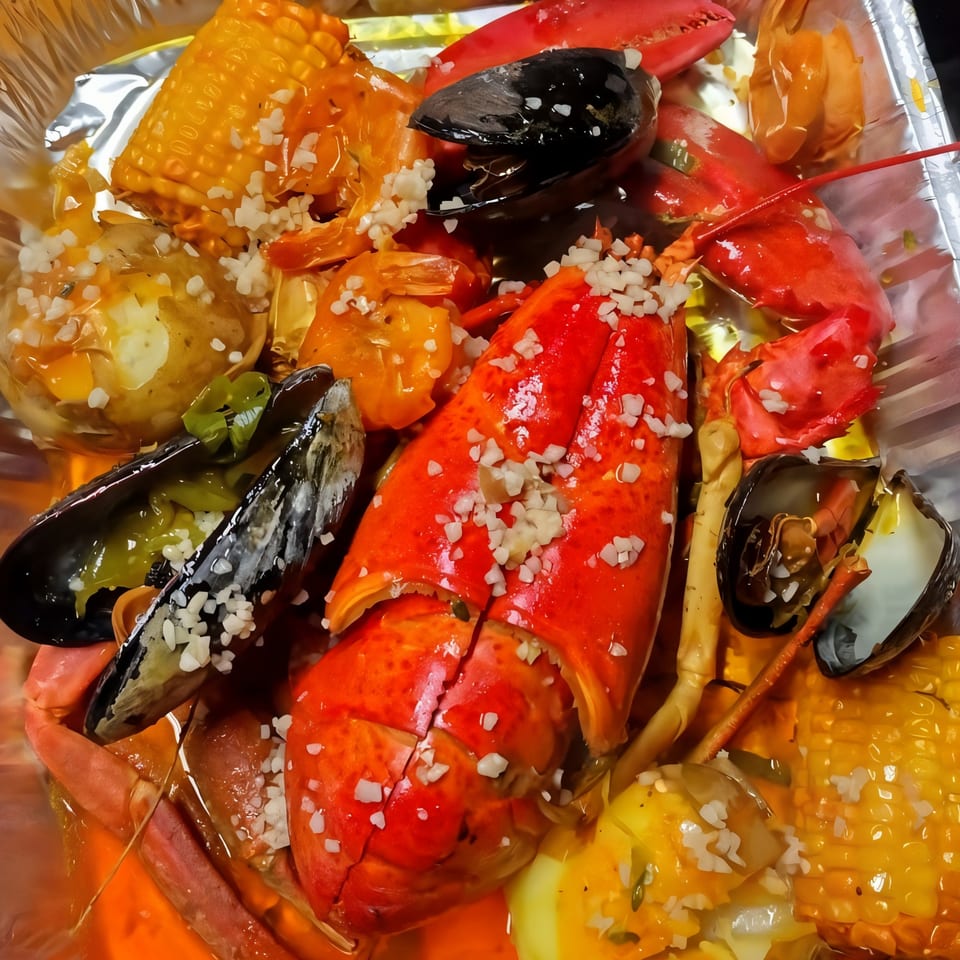 Hellshire Cuisine's Jamaican seafood boil with lobster, mussels, shrimp, corn, and potatoes.